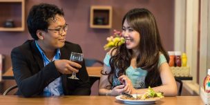 上手な話し方の基本について記された記事中のイメージ画像です。カウンターでワイングラスを傾ける男性が隣の女性に微笑みかけています。