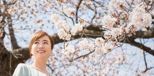 桜の下でほほ笑む女性