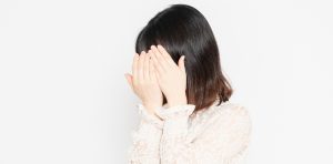 顔隠す女性